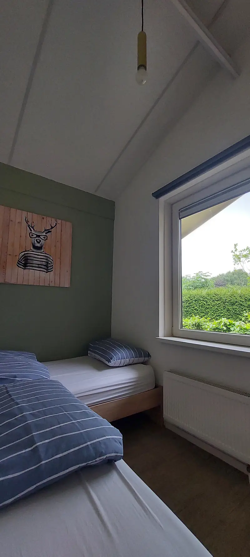 The second bedroom of cottage&nbsp;2, with two single beds and the window onto the hedge.