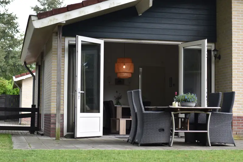 Huisje&nbsp;3 vanaf het gazon, met de deuren naar het terras open.