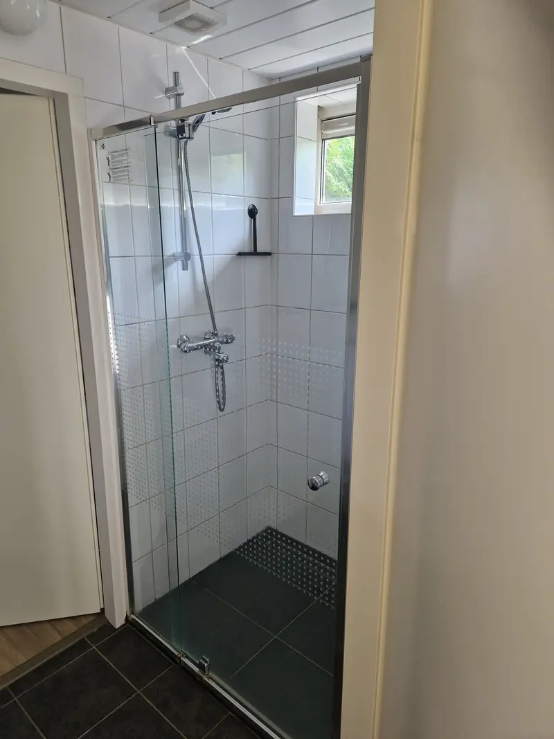 De inloopdouche van huisje&nbsp;3, achter een glazen wand.