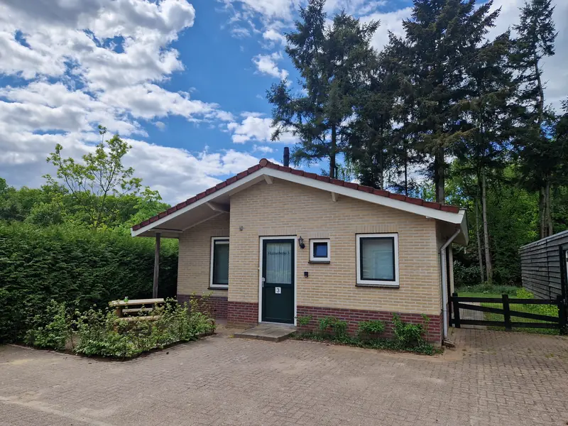 Die Vorderseite von Haus 3 im Sommer, unter blauem Himmel.